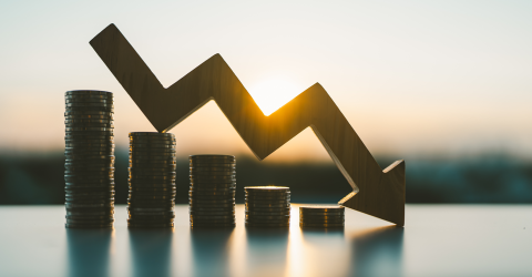 Stapels muntgeld die steeds kleiner worden met een pijl naar beneden erboven